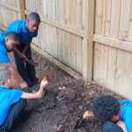 Students digging for worms for garden compost